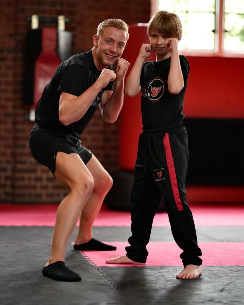 Joe Brooks coaching a young student during a kids kickboxing class in Croydon